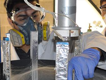 Student with mask doing materials experiment